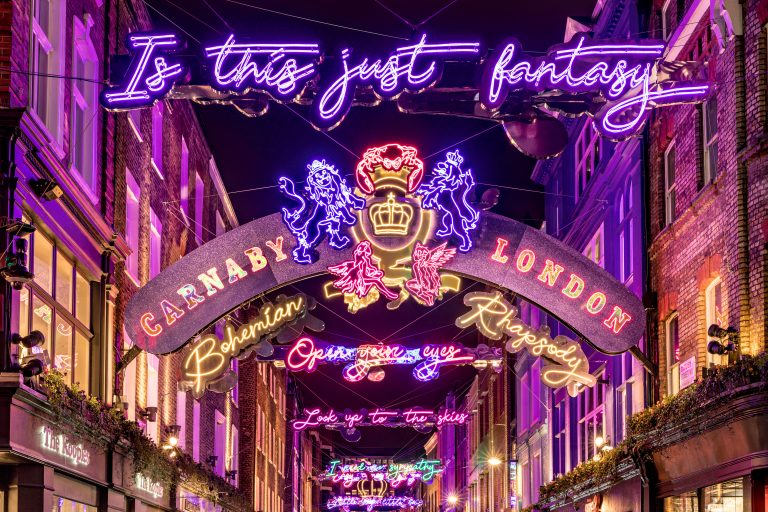 Carnaby Bohemian Rhapsody: neon Queen lyrics and crest above Carnaby Street, London