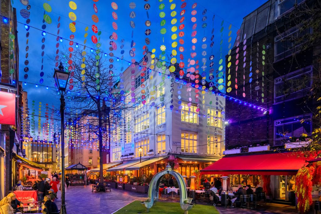 Christmas Discs: colourful hanging disc strands over St Christopher's Place, London