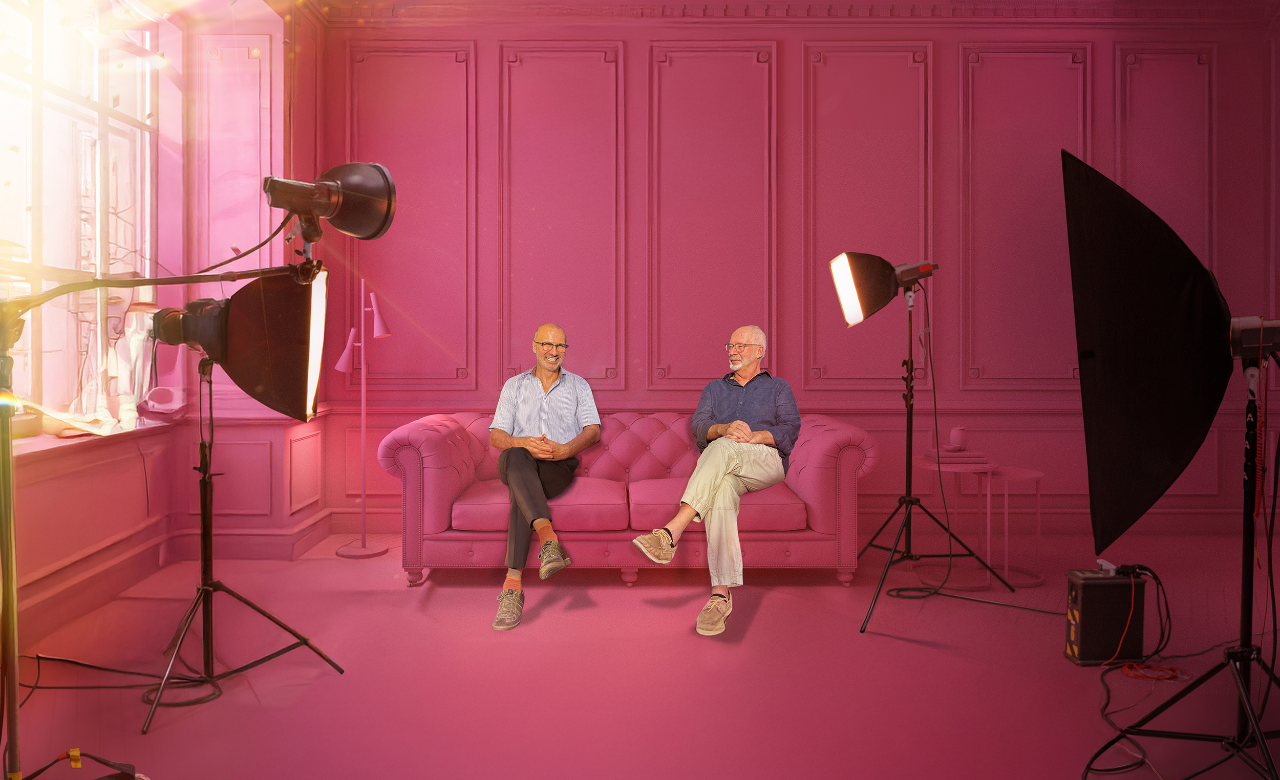 James Glancy and Paul Dart seated on a pink sofa in a photo studio